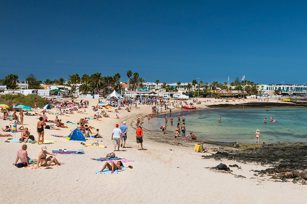 Busy beach scene in Playa de la Goleta in Corralejo